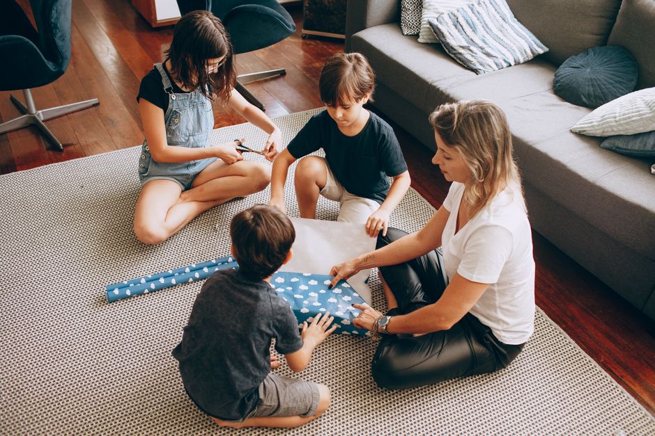 A family wrapping a present together in a cozy living room setting, fostering bonding and collaboration.