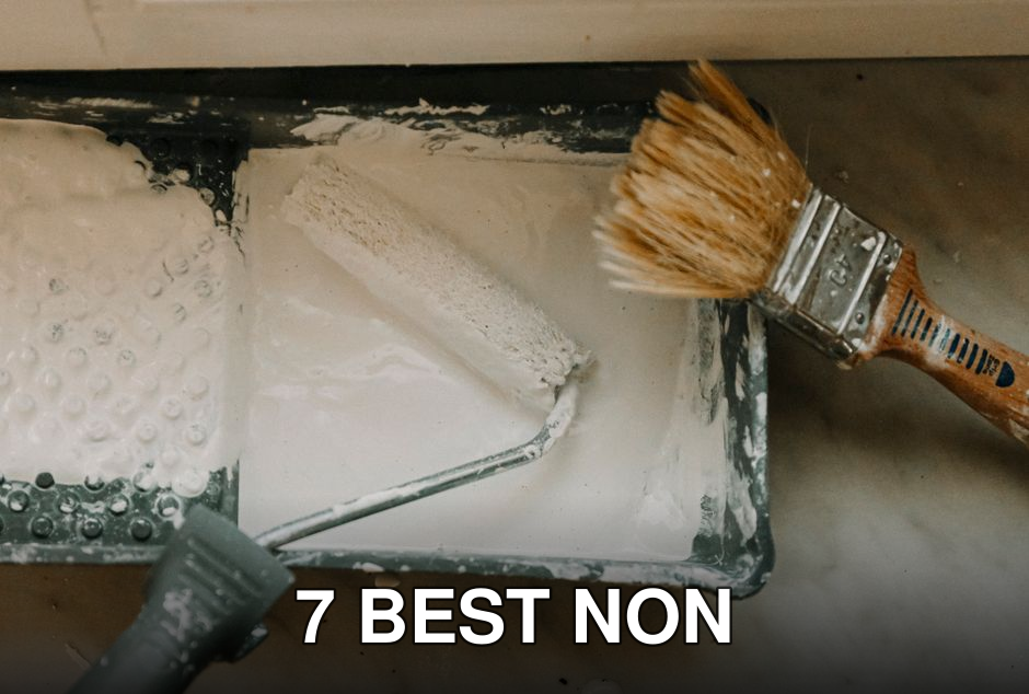 Overhead view of a paint roller and brush in a tray with white paint. Perfect for DIY and home renovation themes.