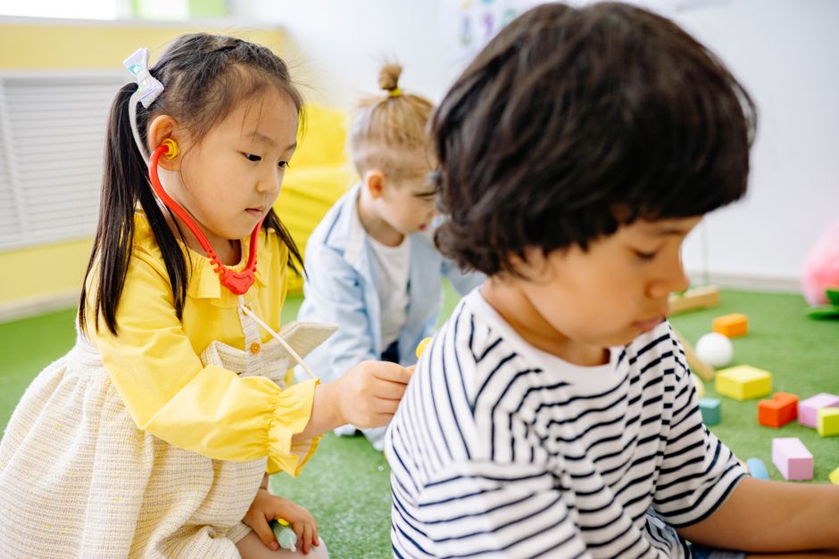 Kids enjoy role-playing as doctors in a vibrant kindergarten setting.