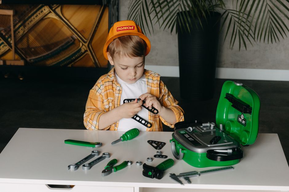 A child playing with a tool set indoors, enhancing creativity and learning.