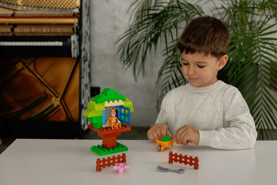 Young boy engages in creative play with colorful construction toys indoors.