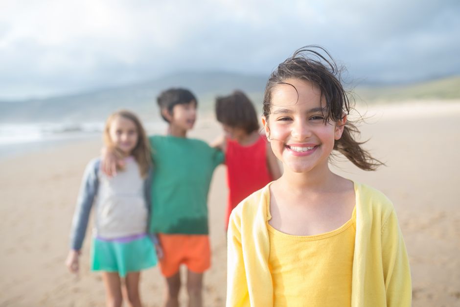 Children playing happily on a scenic beach in Portugal during the day.