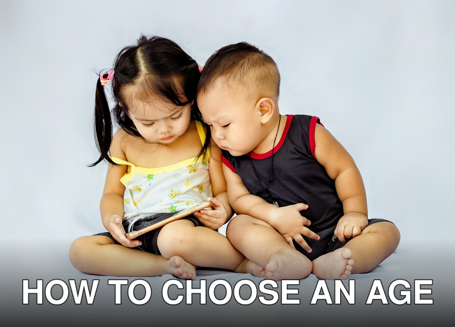 Two young children sitting together and exploring a tablet device in a studio setting.
