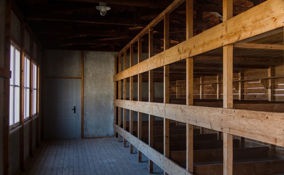 Interior view of wooden barracks highlighting bunk beds in Dachau Memorial, Munich.