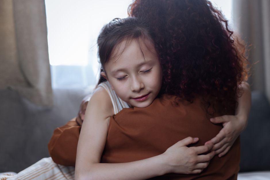 A heartfelt mother-daughter hug indoors, symbolizing love and connection.