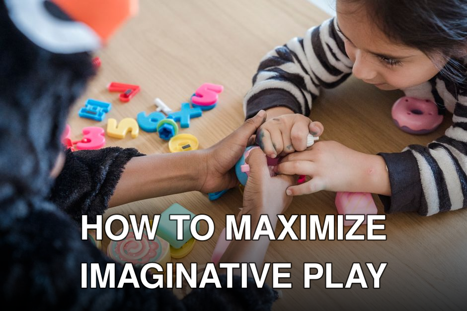 Two children in animal costumes play with colorful toys on a wooden table.