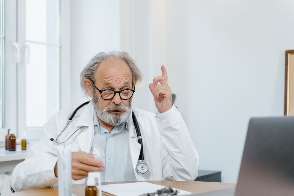 Senior doctor in white coat having an online consultation. Medical professional using technology for healthcare.
