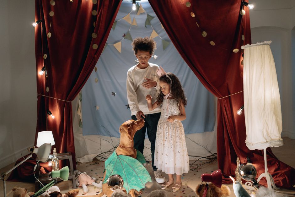 Kids playfully engage with their pet dog in a cozy indoor theater. Warm lighting and joy fill the atmosphere.