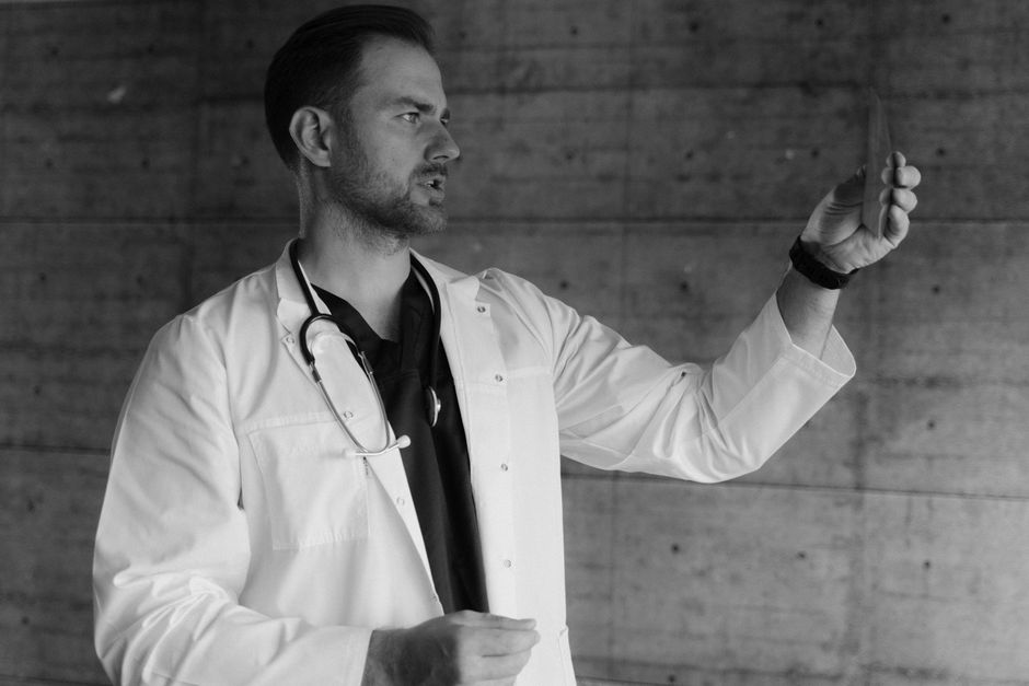A focused male doctor examining an X-ray image with concentration.