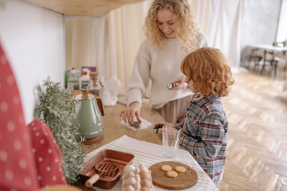 A happy mother and child bonding while baking together in a warm kitchen setting.