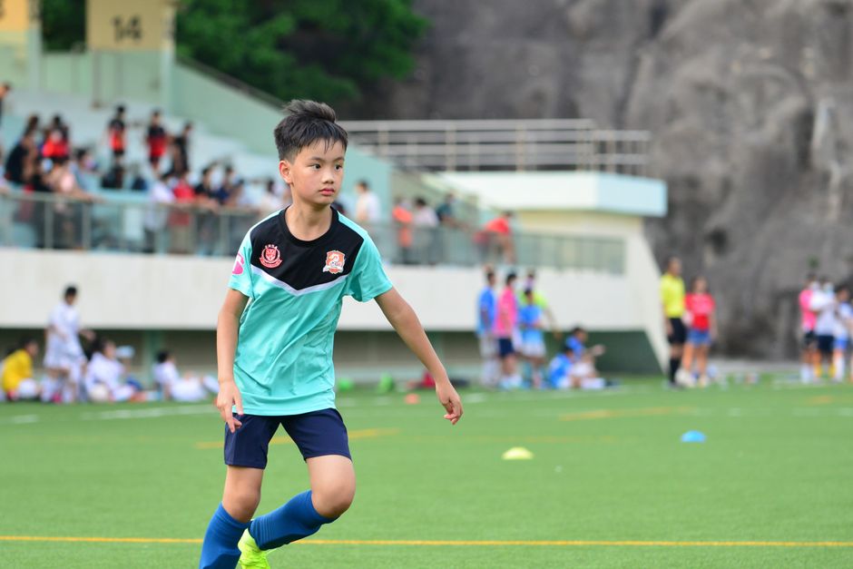 A young boy playing soccer outdoors in a sports field, showcasing his focus and determination. Perfect for sports themes.