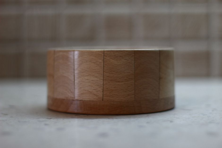 Close-up of a circular wooden bowl on a marble table, showcasing minimalist design.