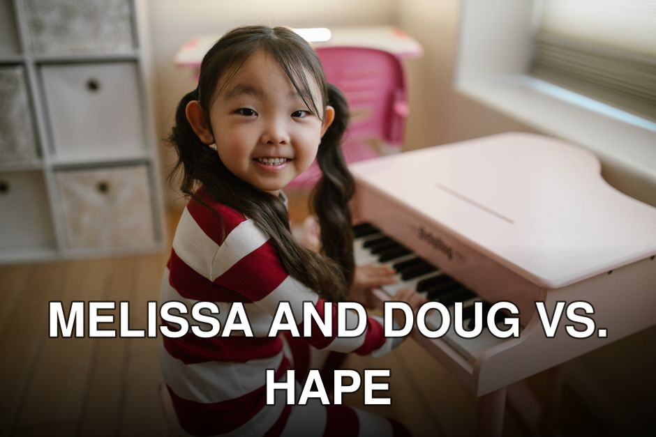 Smiling girl in pajamas playing a pink toy piano in a cozy home setting.