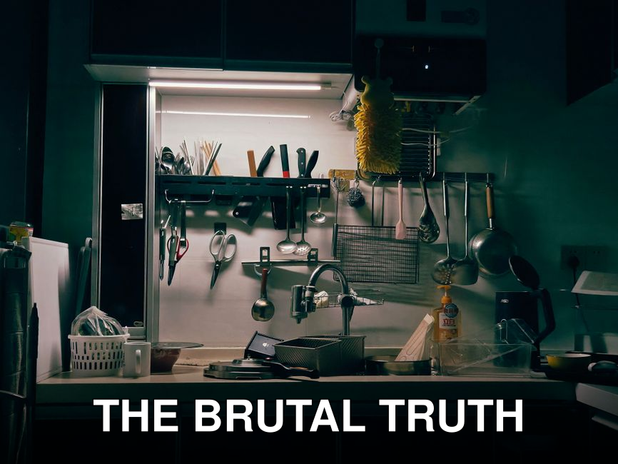 Well-organized kitchen with a variety of hanging utensils and kitchenware around a sink.