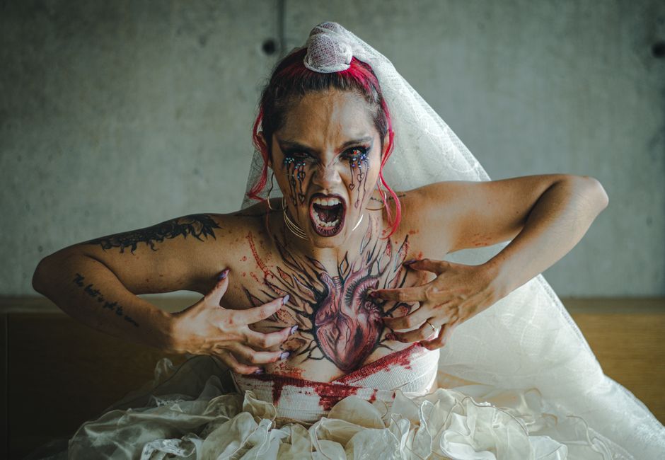 Dramatic portrait of a gothic bride with heart tattoo, expressing fierce emotion and intense style.