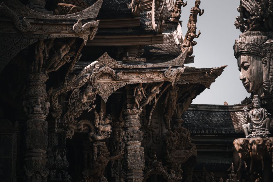 Close-up of detailed wood carvings at the Sanctuary of Truth in Pattaya, Thailand.