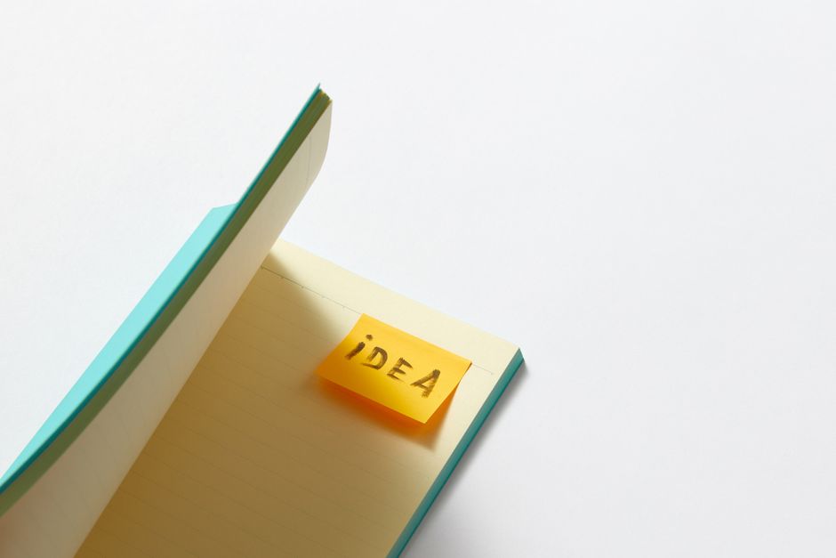 An open notebook with a sticky note labeled 'idea' on a white background, offering creative inspiration.