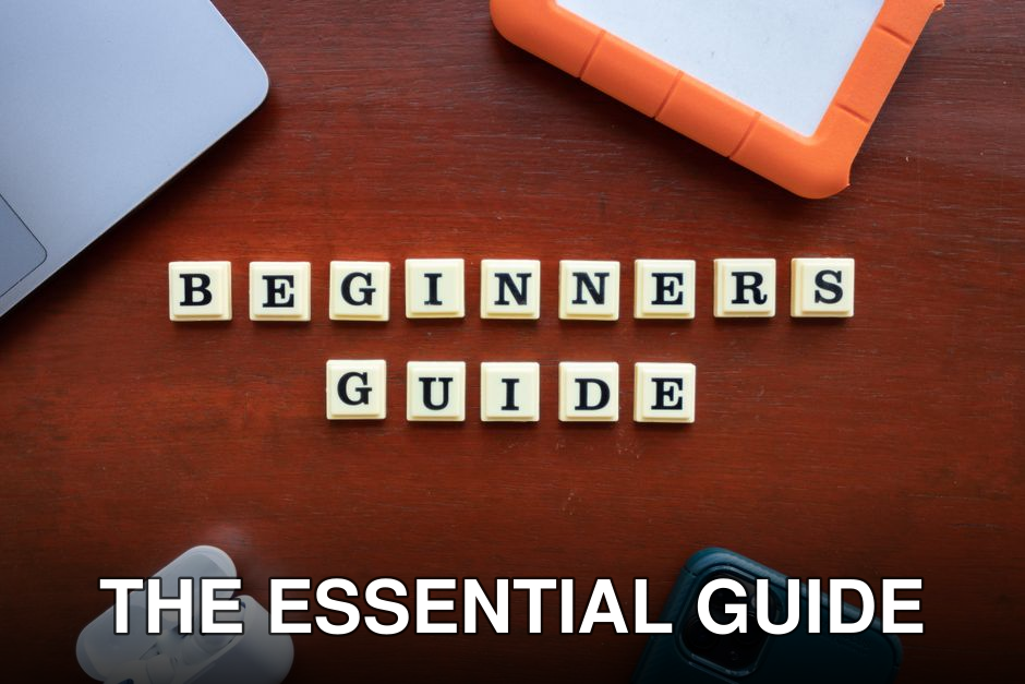 Creative flat lay of gadgets and 'Beginners Guide' text on wooden table.