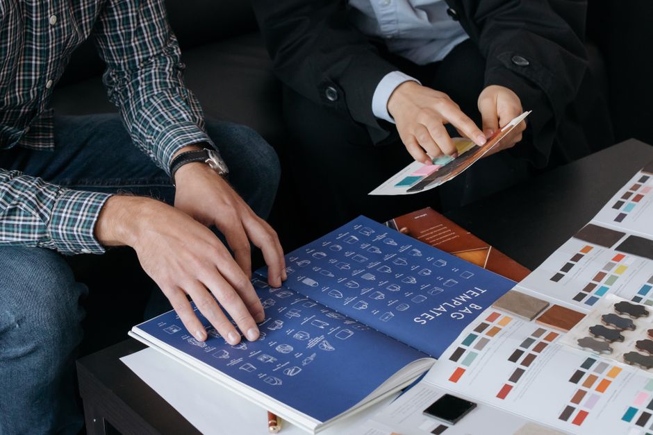 Close-up of designers reviewing bag templates and color swatches at a workspace.
