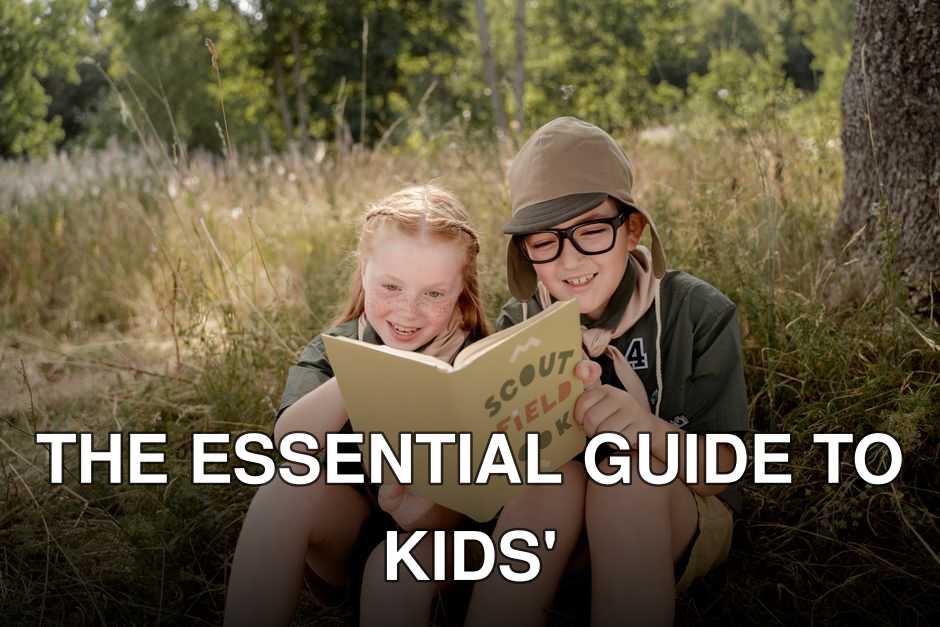 Two children in scout uniforms reading a field book in a forest setting.