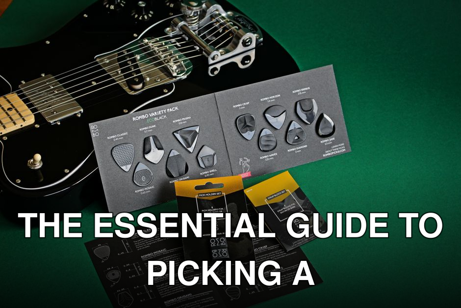 Black electric guitar with variety of guitar picks on a green background.