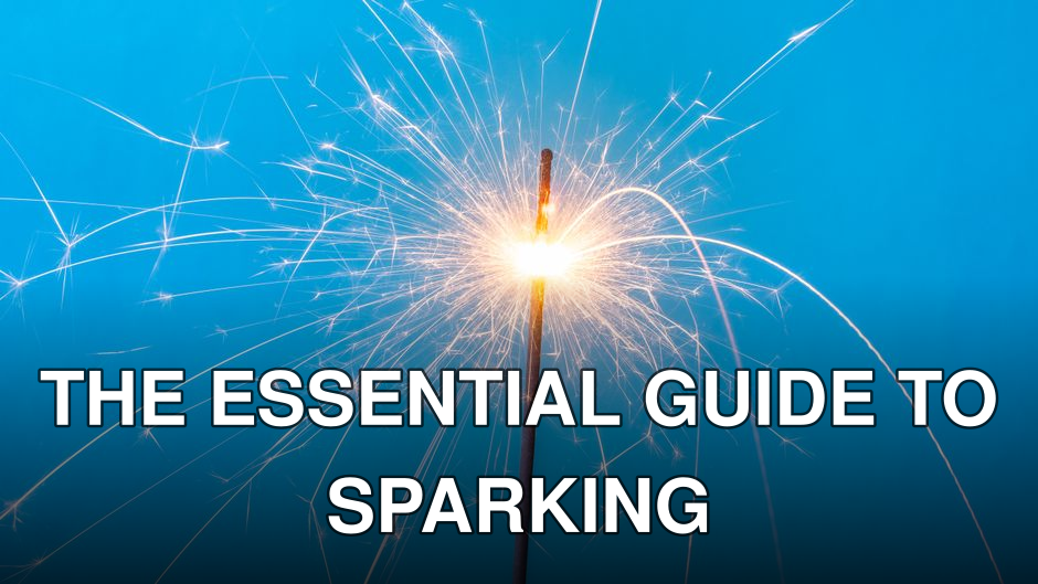 Close-up of a sparking sparkler against a blue background, symbolizing celebration and joy.