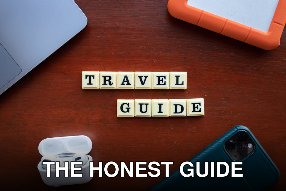 Flat lay of travel guide concept with smartphone, laptop, and headphones.