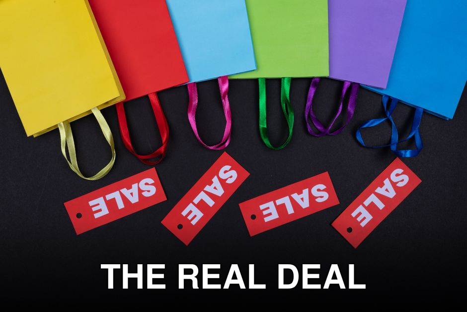 Vibrant shopping bags with sale tags on a black surface. Perfect for retail promotions.