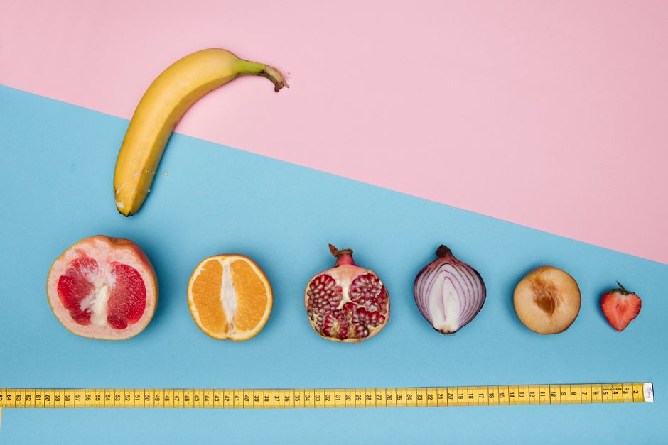 Colorful fruits and vegetables including banana, citrus, and onion creatively arranged with a measuring tape.