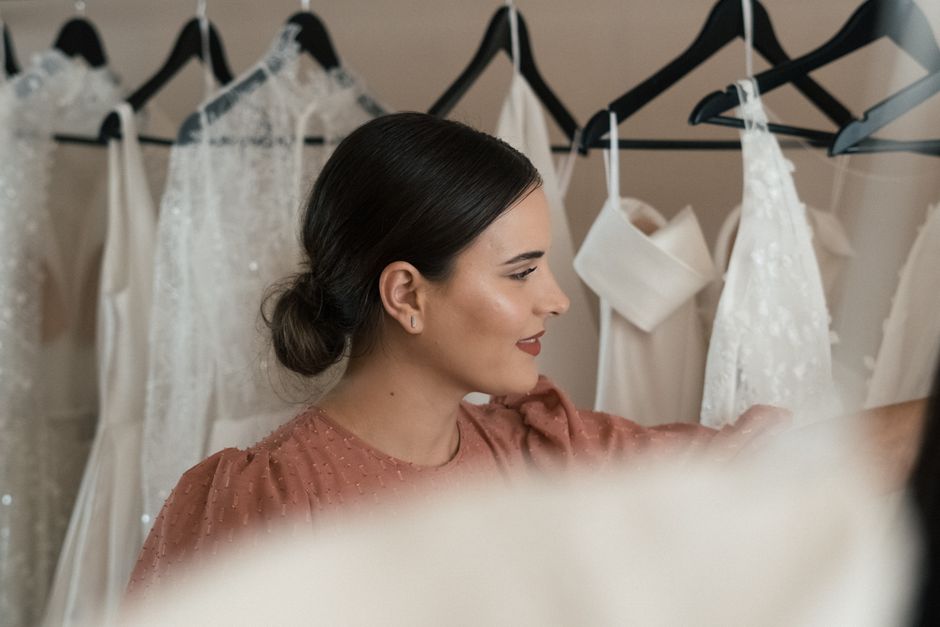 Bride-to-be selecting a wedding dress in a chic bridal boutique.