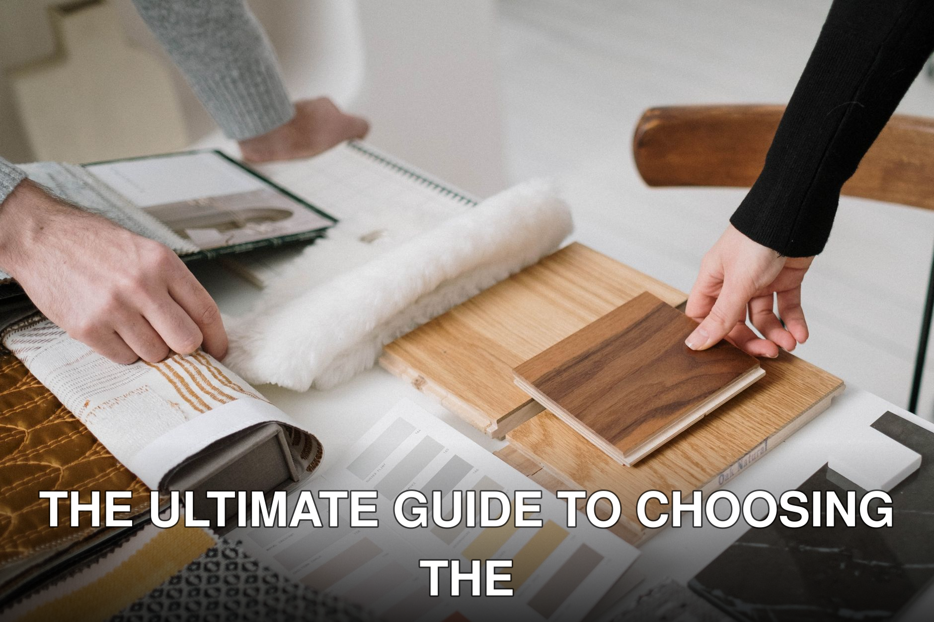 Hands selecting and comparing textile and wood samples for interior design.