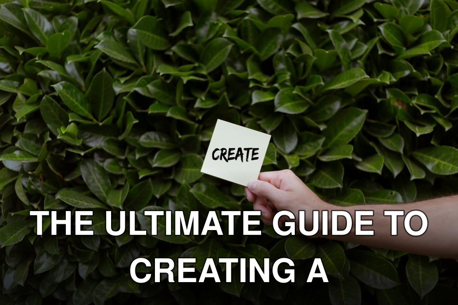 A hand holding a note with 'Create' written on it against a lush green leafy background.