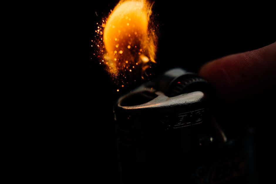 Captivating macro shot of lighter igniting sparks and flame against a dark background.