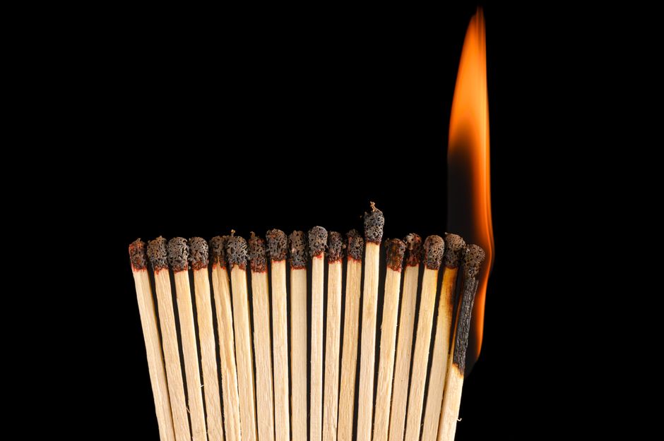 A striking close-up of matchsticks igniting in chain reaction, symbolic of spreading ideas.