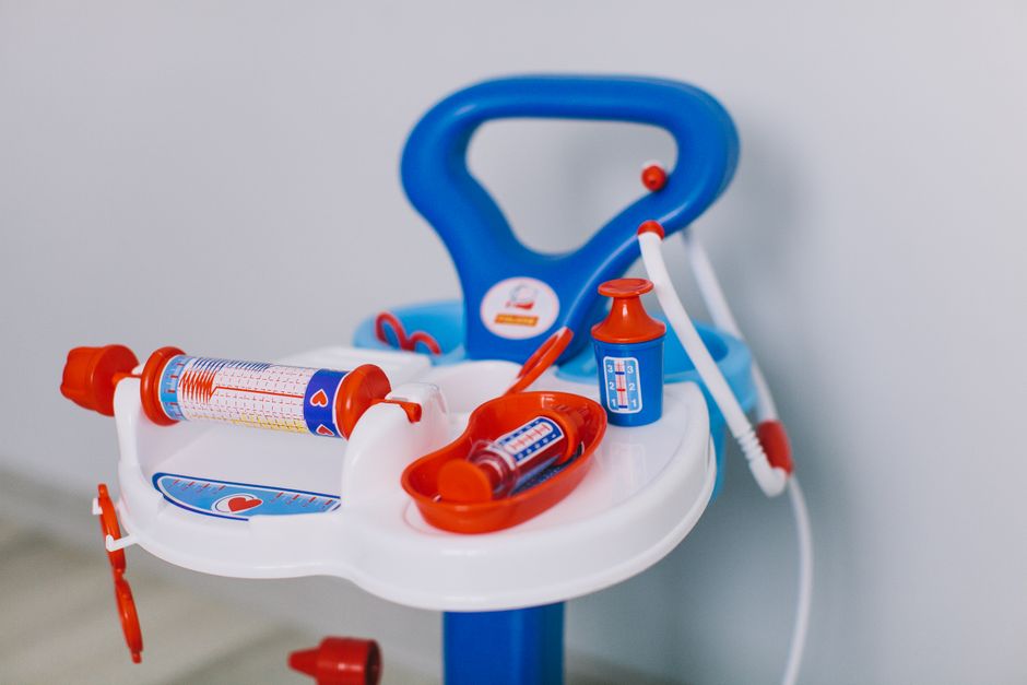 Bright toy medical set with syringes and bottles on white tray for kids' role play.