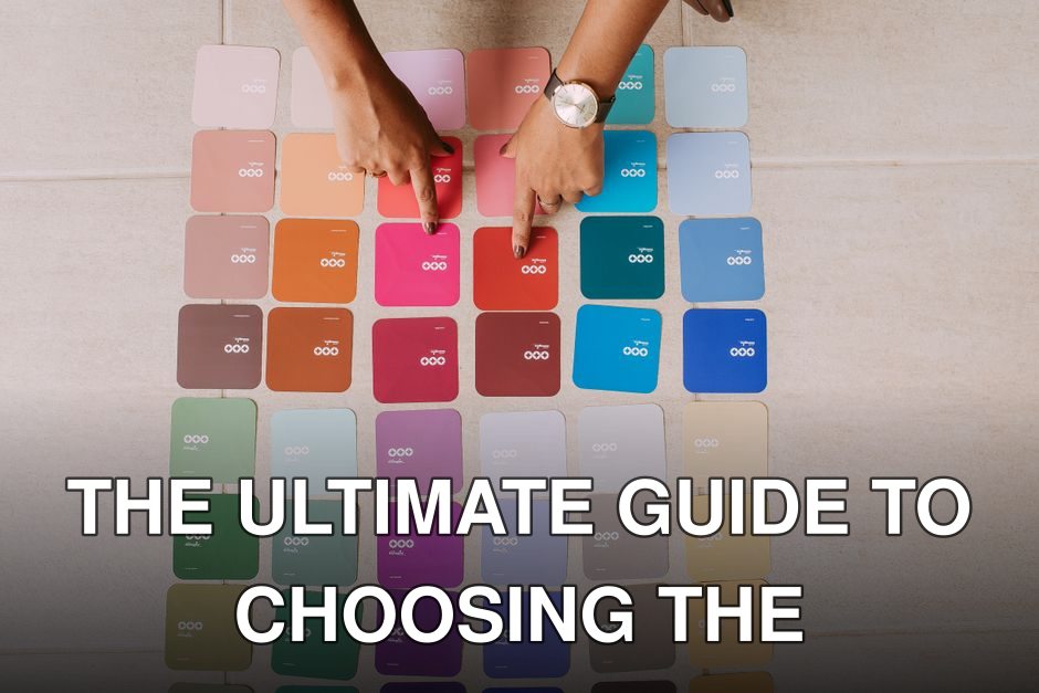 Top view of hands pointing at various color palette cards on a table, showcasing diverse options.
